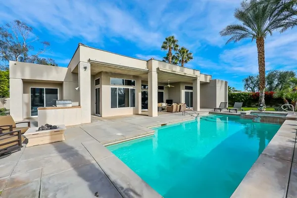 a view of a house with swimming pool and sitting area