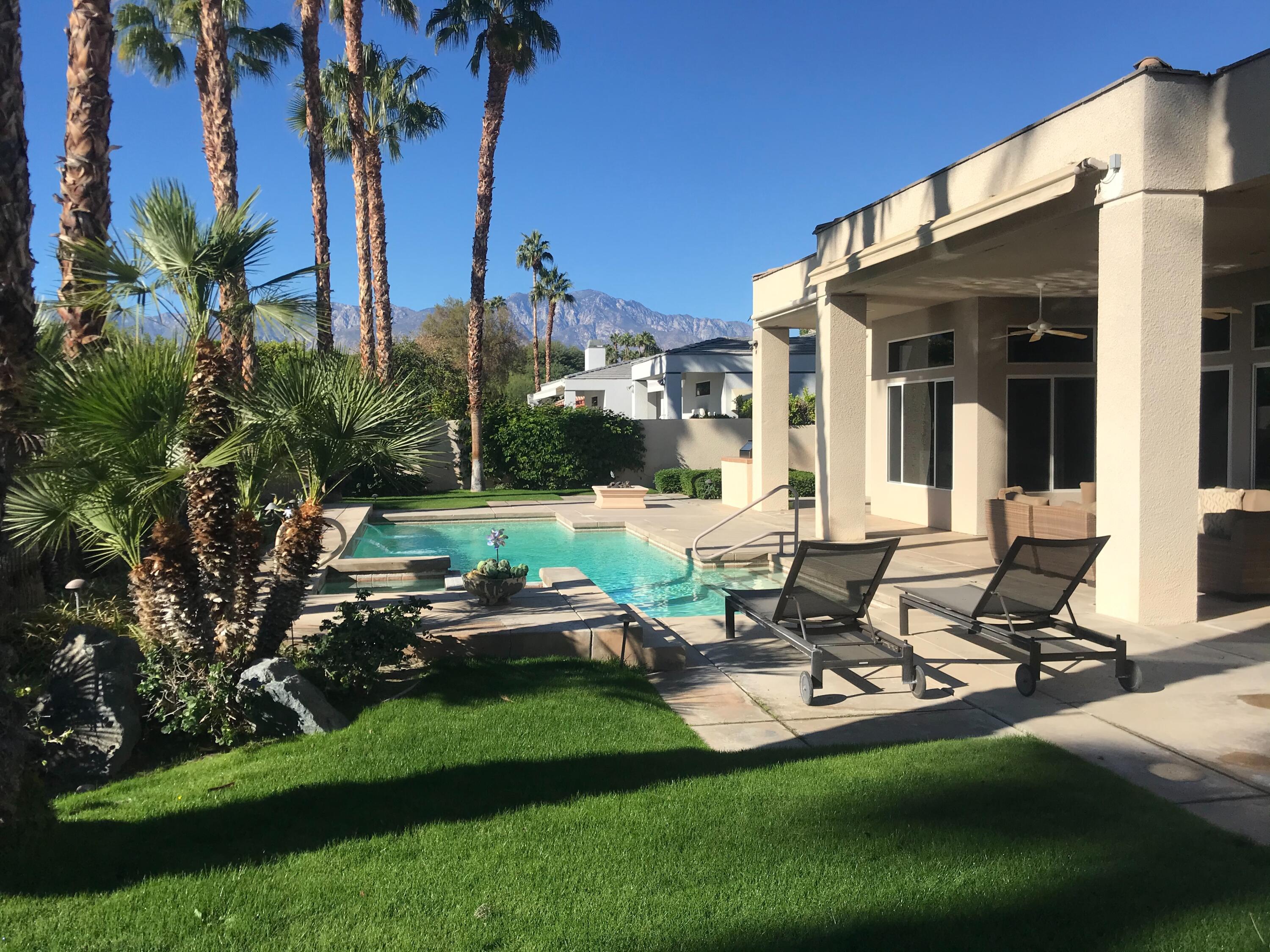 70955 Sunny Lane Rancho Mirage, CA 92270 - Photo 27 of 35 a view of a patio with table and chairs potted plants and palm tree