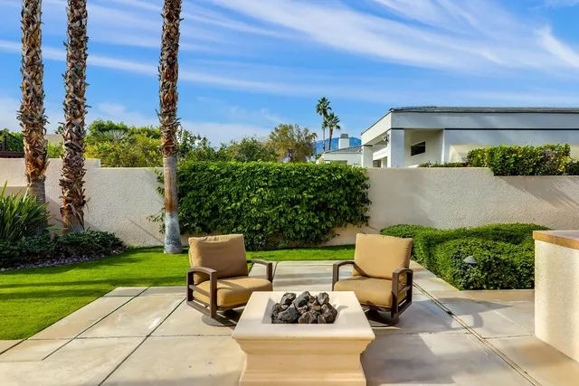 a view of a patio with couches table and chairs and potted plants