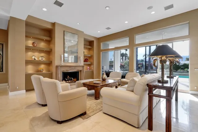 a living room with fireplace furniture and a large window