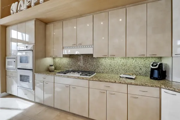 a kitchen with stainless steel appliances granite countertop white cabinets and a granite counter tops