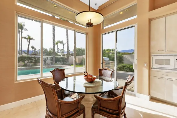 a dining room with furniture a chandelier and a large window
