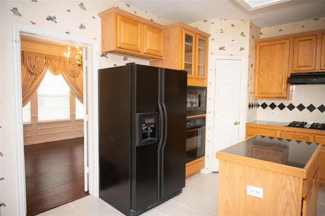 a kitchen with stainless steel appliances granite countertop a refrigerator and a stove