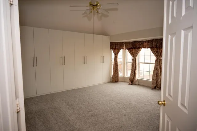 an empty room with windows and closet