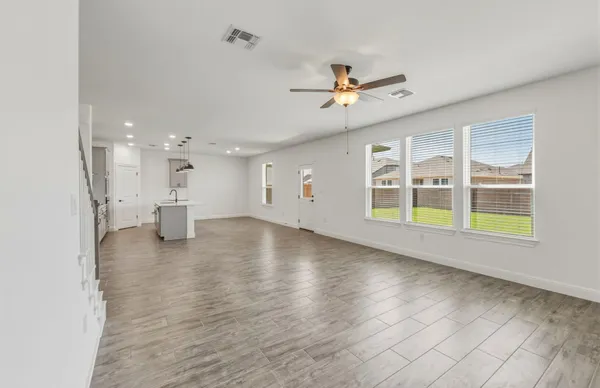 a view of a kitchen with wooden floor and a ceiling fan