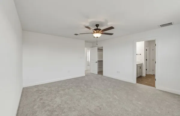 an empty room with windows and ceiling fan
