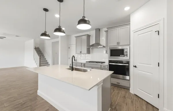 a kitchen with a sink a stove and cabinets
