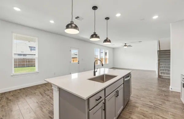 a kitchen with a sink a stove and chairs