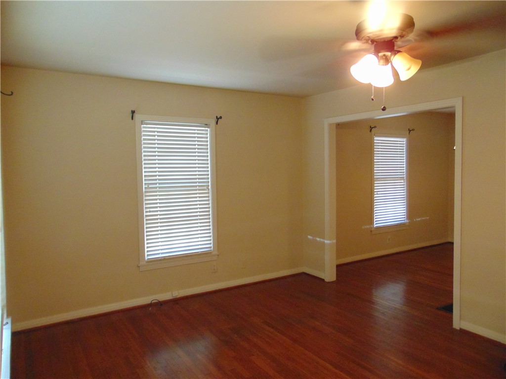 1508 Richcreek Road Austin, TX 78757 - Photo 4 of 10 a view of an empty room with a window and wooden floor