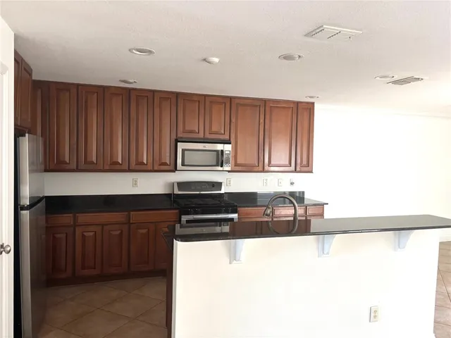 a kitchen with stainless steel appliances granite countertop a stove a sink and a microwave