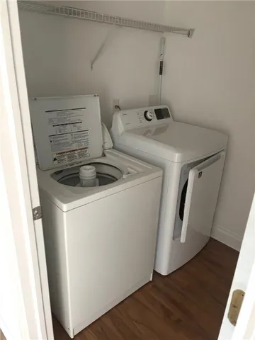 a utility room with wooden floor washer and dryer
