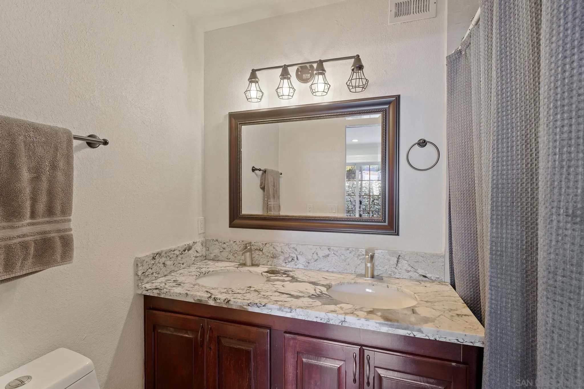 14433 Range Park Road Poway, CA 92064 - Photo 27 of 46 a bathroom with a granite countertop sink a toilet and mirror