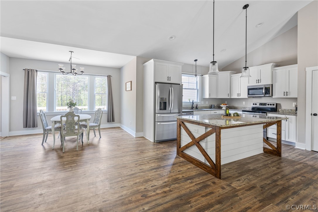 3925 Old Ridge Road Farmville, VA 23901 - Photo 10 of 50 a kitchen with stainless steel appliances kitchen island granite countertop a refrigerator a stove a dining table and chairs with wooden floor