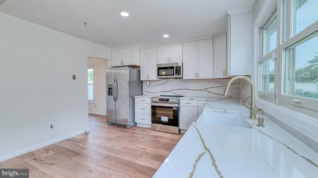 a kitchen with stainless steel appliances granite countertop a refrigerator and a stove top oven