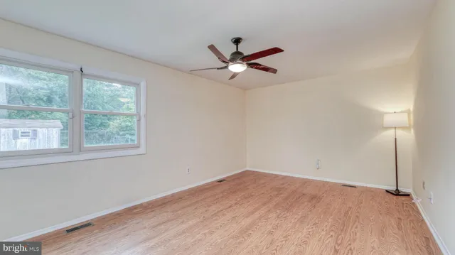 a view of a big room with wooden floor and a window