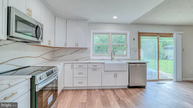 a kitchen with cabinets appliances and a large window
