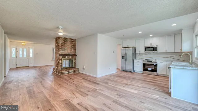 a view of kitchen with microwave a stove and wooden floor