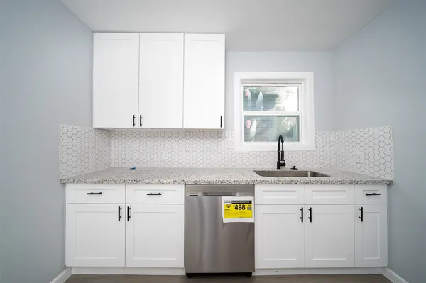 a kitchen with a white cabinets sink and stove