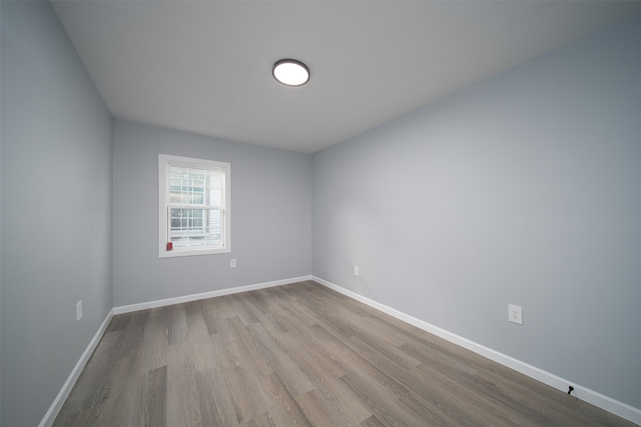 3120 Stonewall Street Houston, TX 77020 - Photo 4 of 18 an empty room with wooden floor and windows