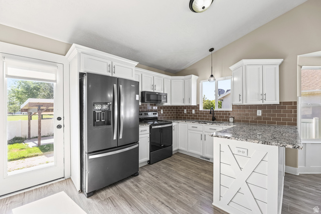 5525 Hampton Way Stansbury Park, UT 84074 - Photo 6 of 35 Modern kitchen featuring white cabinetry, a brown subway tile backsplash, and wood-finish flooring