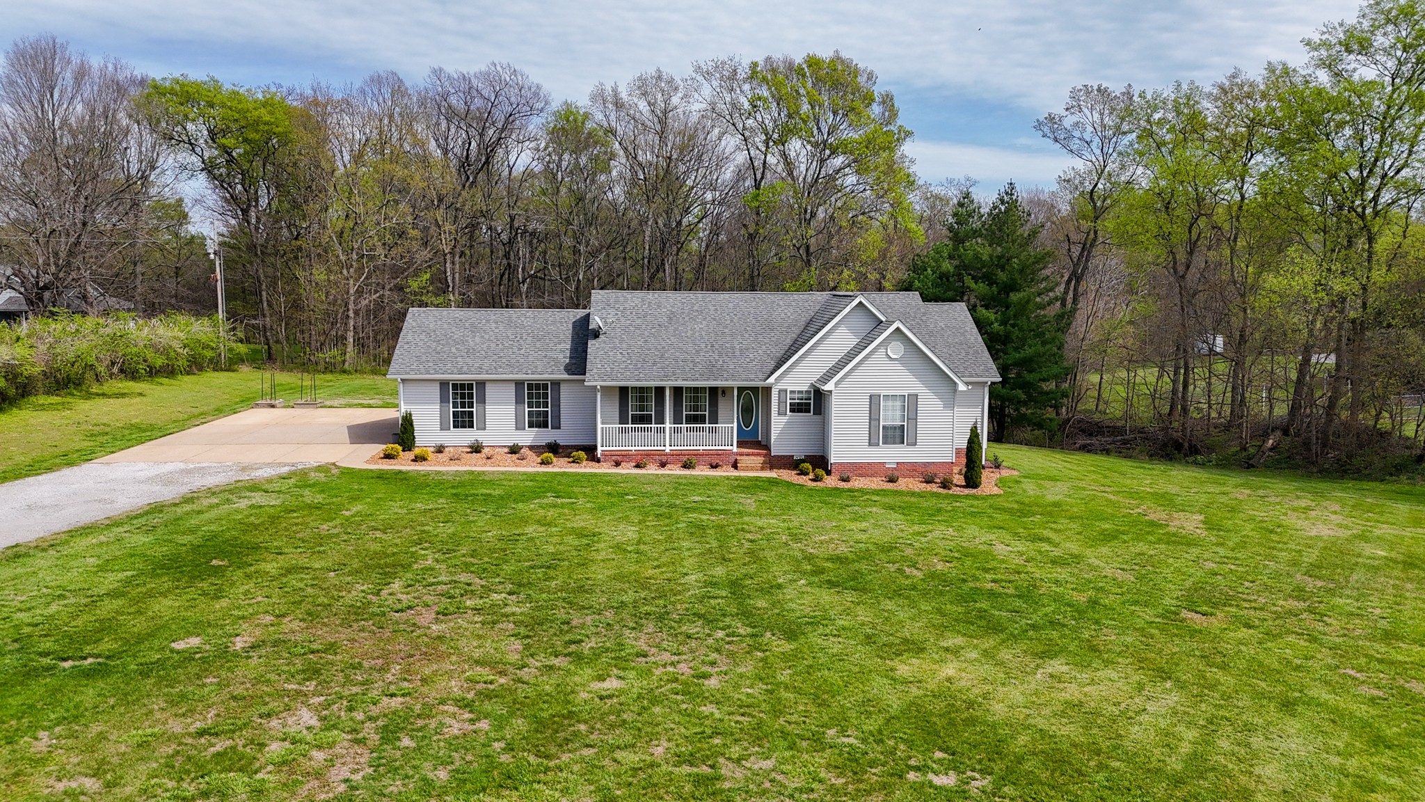 a aerial view of a house with a big yard and large trees