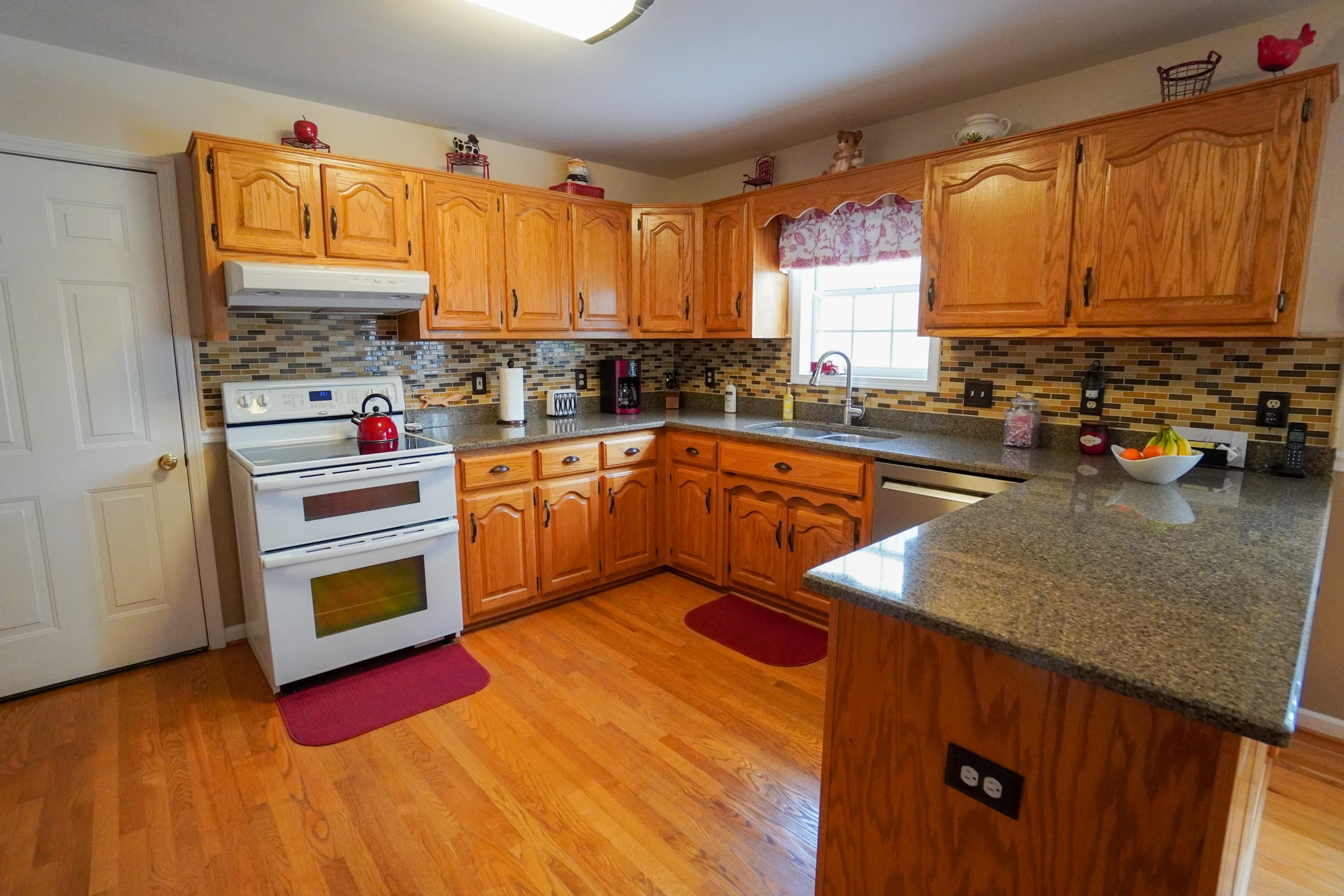 1890 Clara Mathis Road Spring Hill, TN 37174 - Photo 18 of 45 a kitchen with stainless steel appliances granite countertop a sink dishwasher stove and cabinets with wooden floor