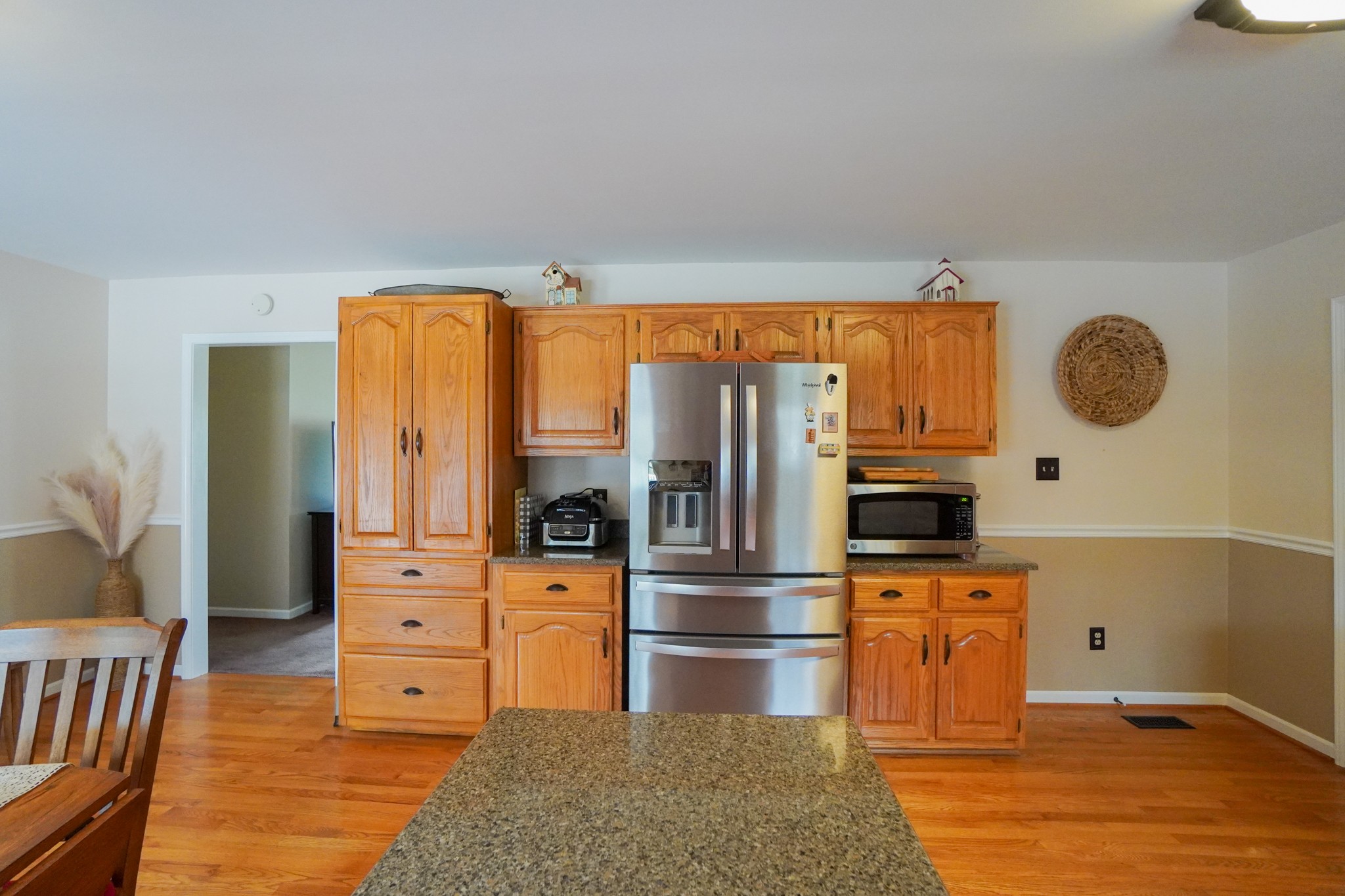 1890 Clara Mathis Road Spring Hill, TN 37174 - Photo 22 of 45 a kitchen with stainless steel appliances kitchen island granite countertop a refrigerator oven stove a dining table and chairs with wooden floor