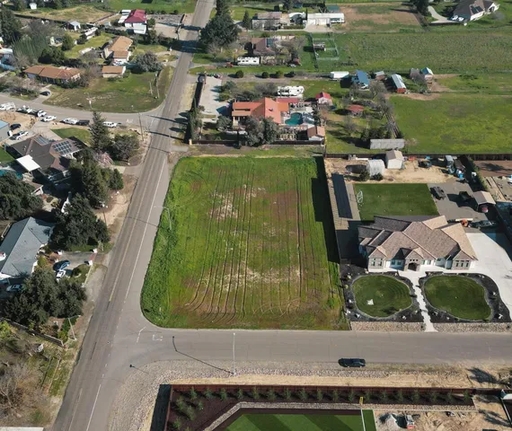 an aerial view of a house with a garden and lake view
