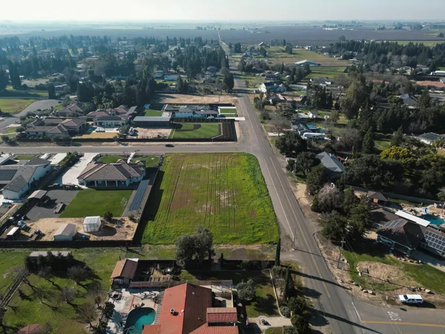 an aerial view of a house with a garden and mountain view in back