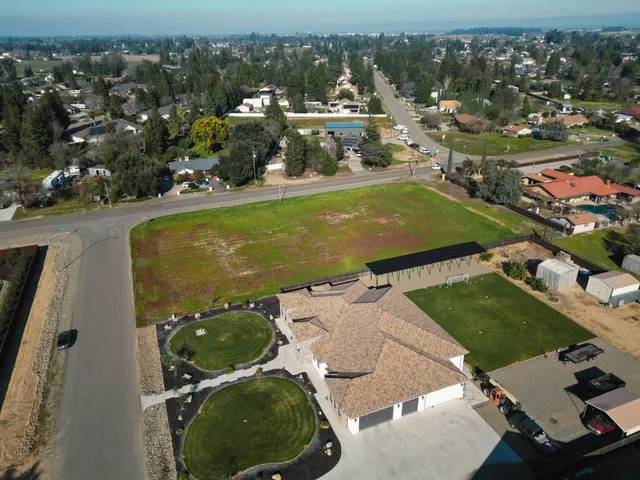 an aerial view of a resort with swimming pool tennis courts and ocean view