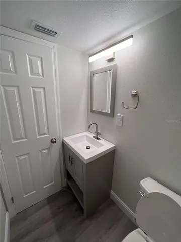 a bathroom with a sink and mirror with toilet