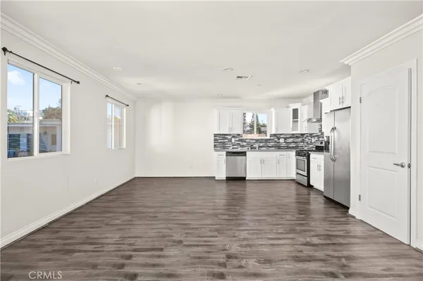a view of kitchen with granite countertop cabinets and refrigerator