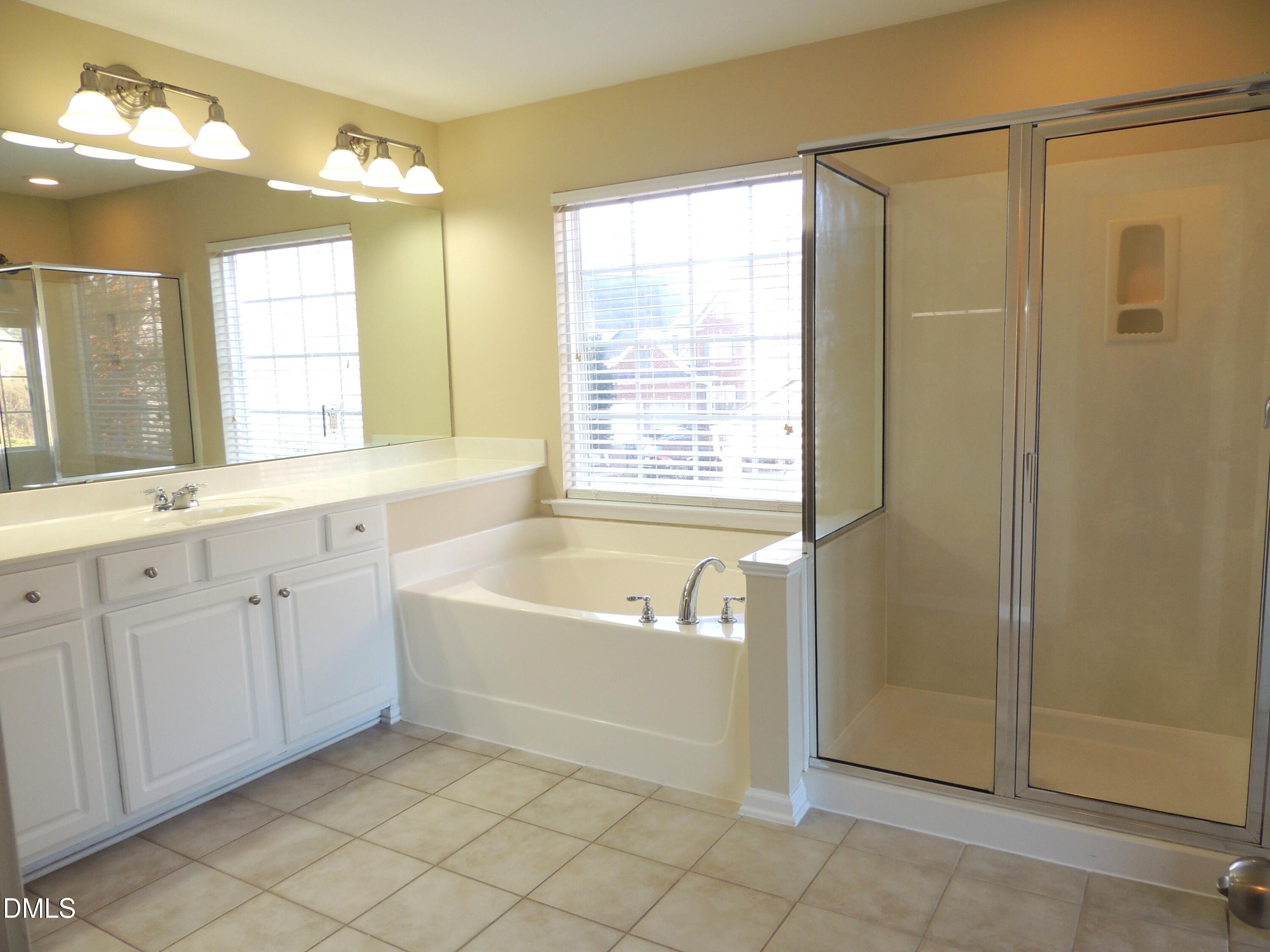 12544 Honeychurch Street Raleigh, NC 27614 - Photo 13 of 24 a spacious bathroom with a bathtub a shower and a sink