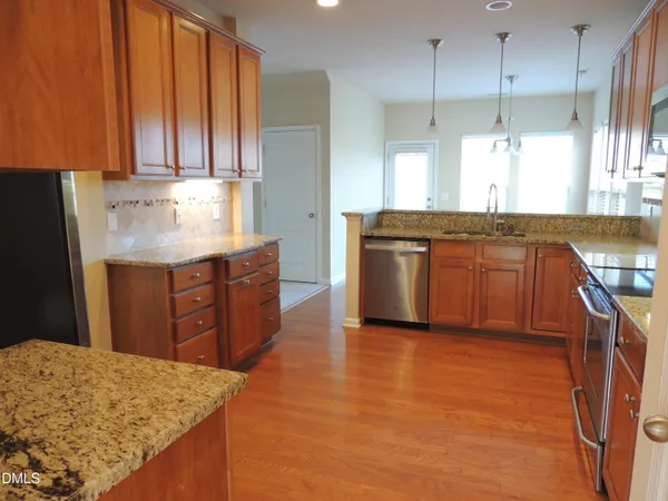 a kitchen with stainless steel appliances granite countertop a stove a sink and a refrigerator