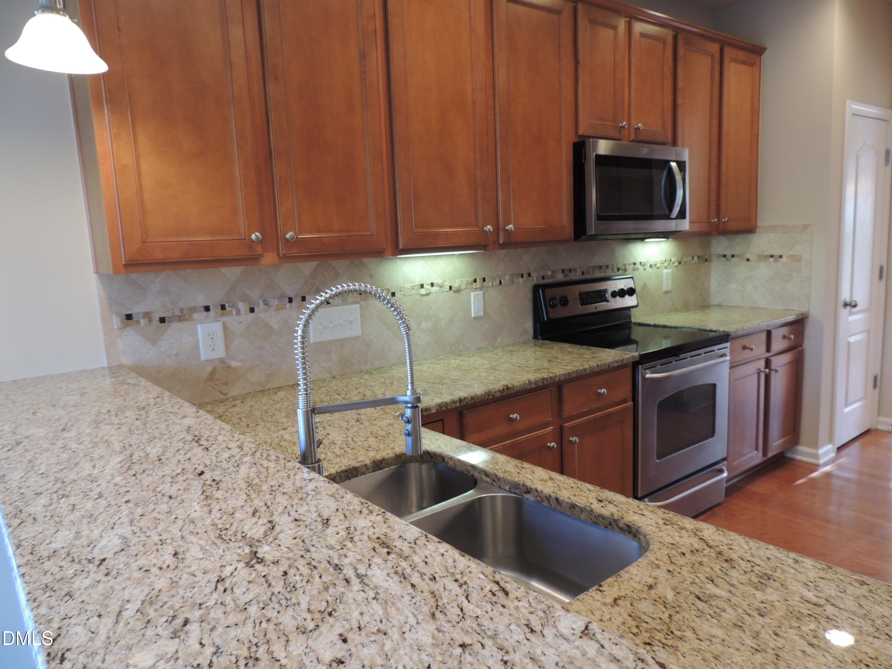 12544 Honeychurch Street Raleigh, NC 27614 - Photo 5 of 24 a kitchen with stainless steel appliances granite countertop a sink a stove a microwave and a oven