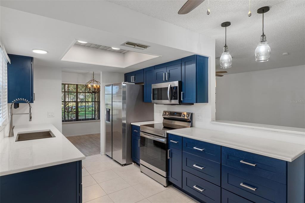 2129 Point O Woods Court Spring Hill, FL 34606 - Photo 2 of 76 a kitchen with stainless steel appliances a sink a stove a refrigerator cabinets and a dining table