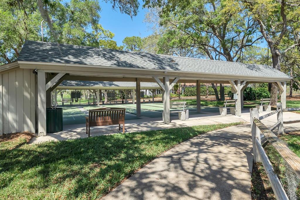 2129 Point O Woods Court Spring Hill, FL 34606 - Photo 51 of 76 a view of a chair and tables in the patio next to a yard