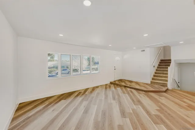 a view of a livingroom with wooden floor and a window