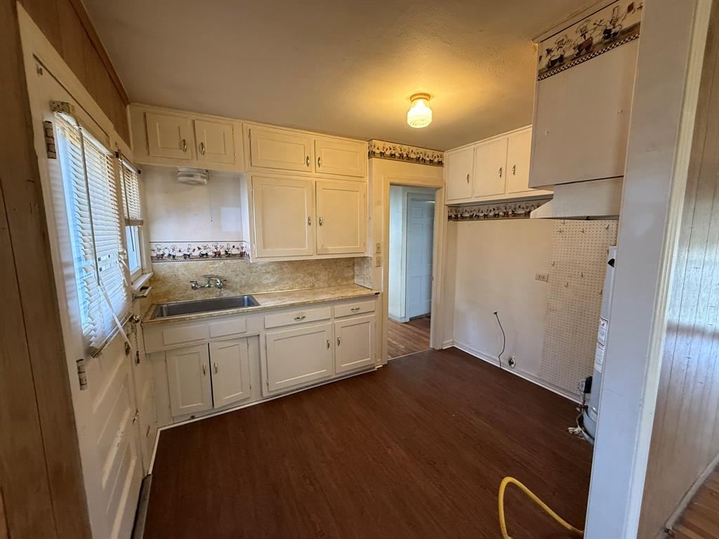 3211 North 25th Street Waco, TX 76708 - Photo 4 of 12 a kitchen with granite countertop white cabinets and white appliances