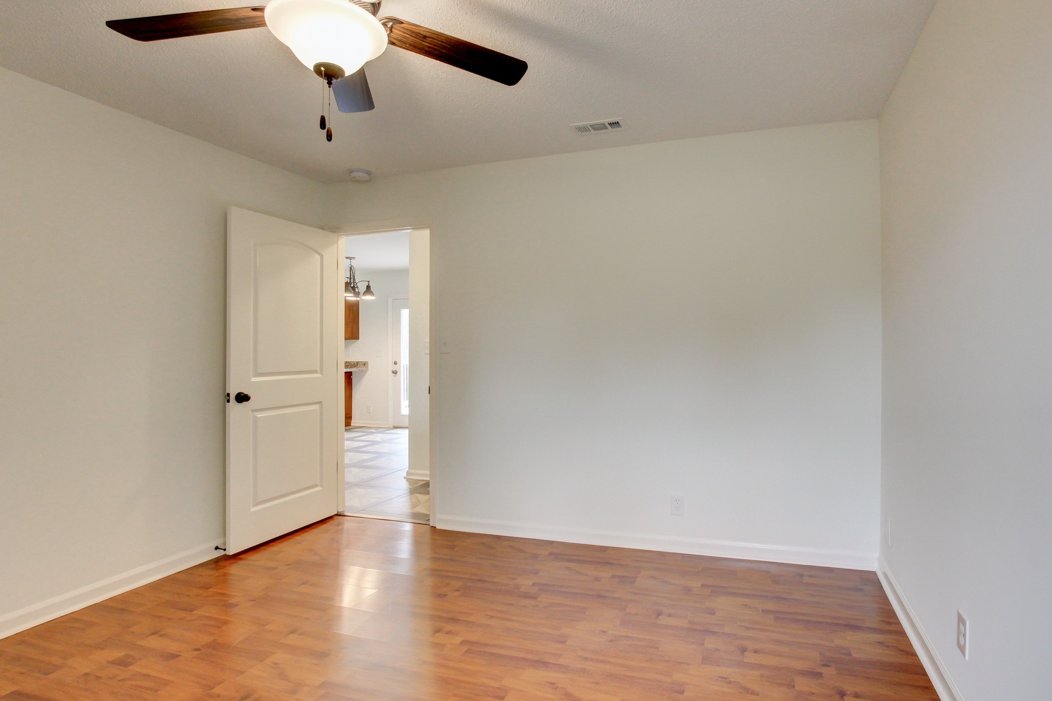 825 Pollard Road Clarksville, TN 37042 - Photo 33 of 44 an empty room with wooden floor chandelier fan and entryway