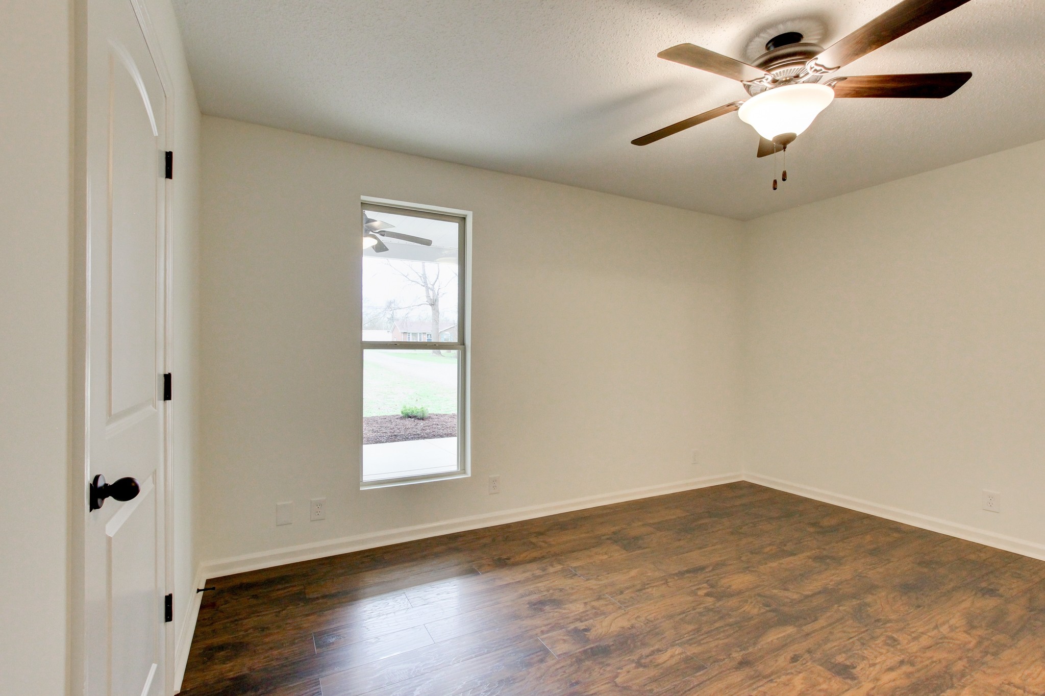 825 Pollard Road Clarksville, TN 37042 - Photo 38 of 44 an empty room with wooden floor ceiling fan and window