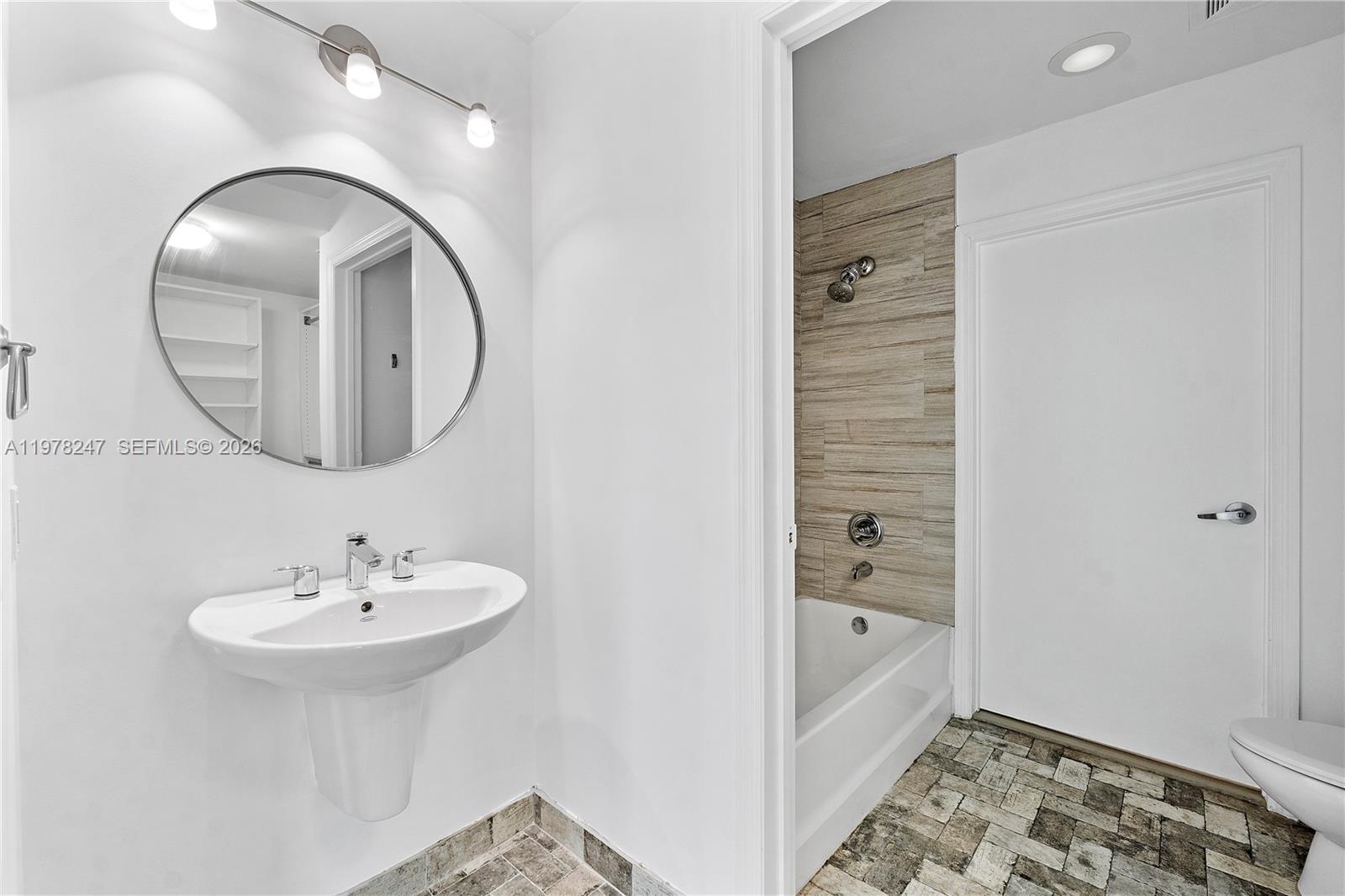60 Southwest 13th Street, Unit 1921 Miami, FL 33130 - Photo 20 of 23 a bathroom with a sink a mirror and a bathtub