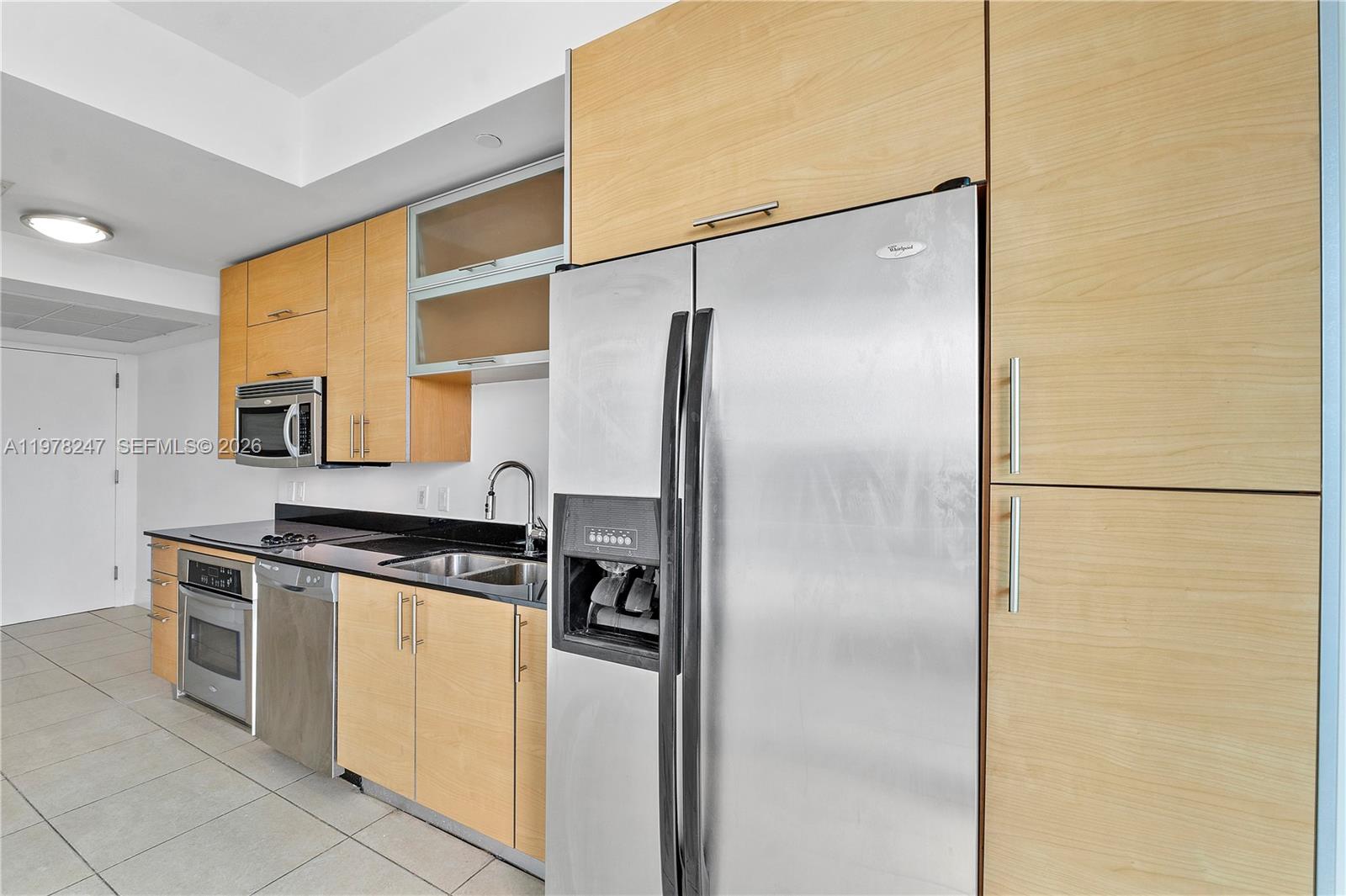 60 Southwest 13th Street, Unit 1921 Miami, FL 33130 - Photo 3 of 23 a kitchen with a refrigerator a stove top oven and cabinets