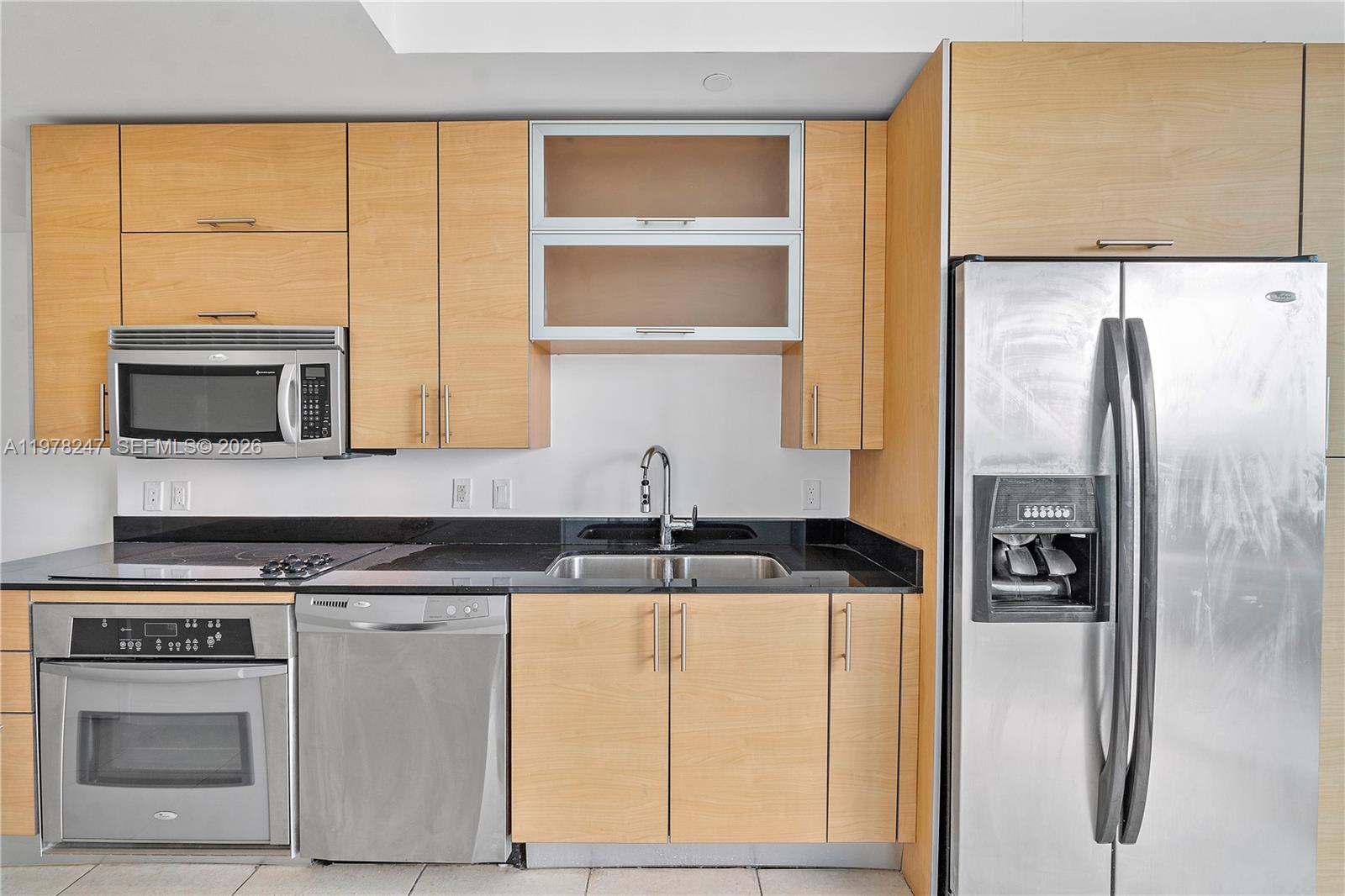 60 Southwest 13th Street, Unit 1921 Miami, FL 33130 - Photo 4 of 23 a kitchen with granite countertop a refrigerator and a sink