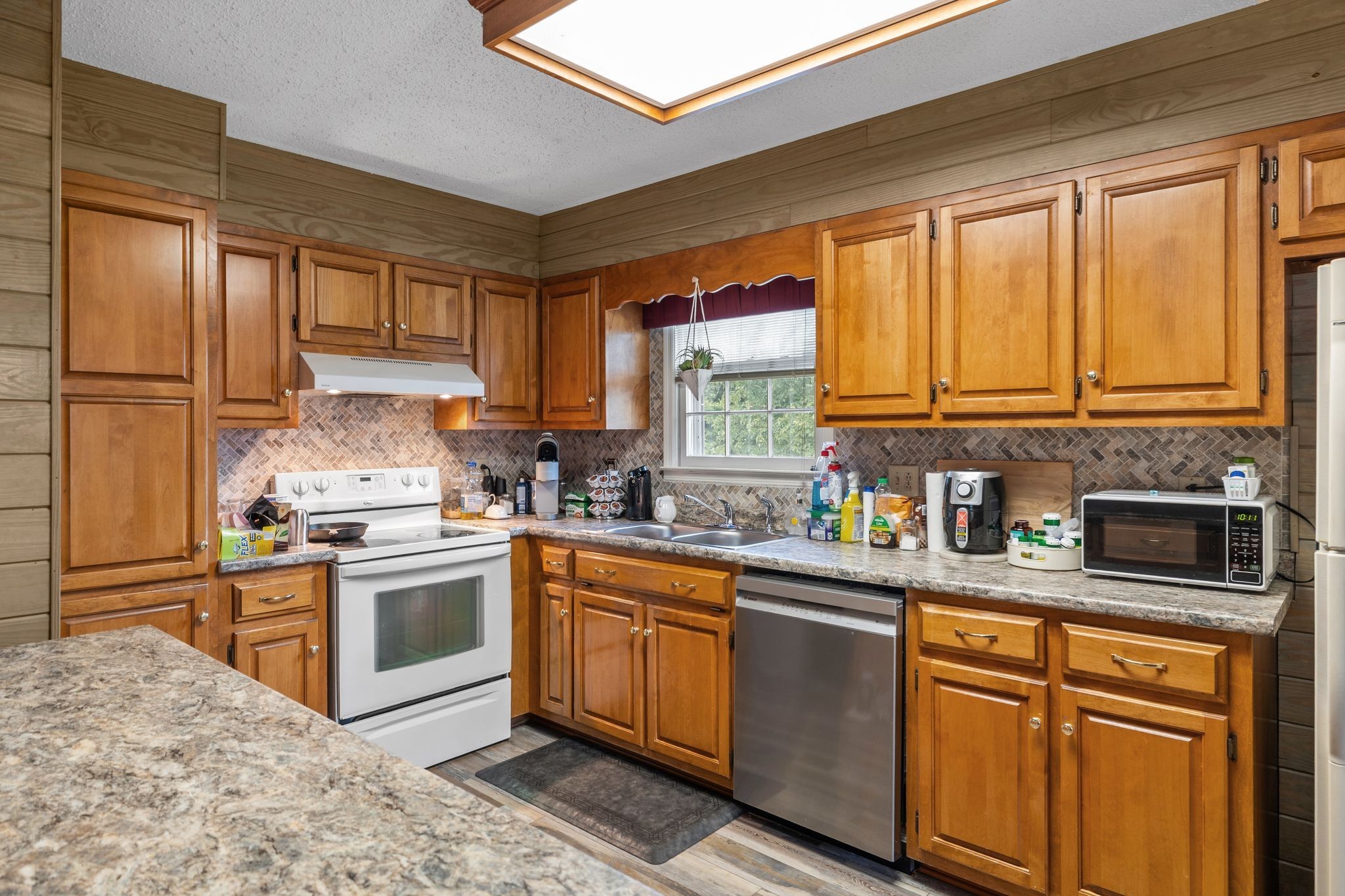 4628 Dugger Road Culleoka, TN 38451 - Photo 16 of 40 a kitchen with stainless steel appliances granite countertop a stove a sink dishwasher a refrigerator and cabinets with wooden floor