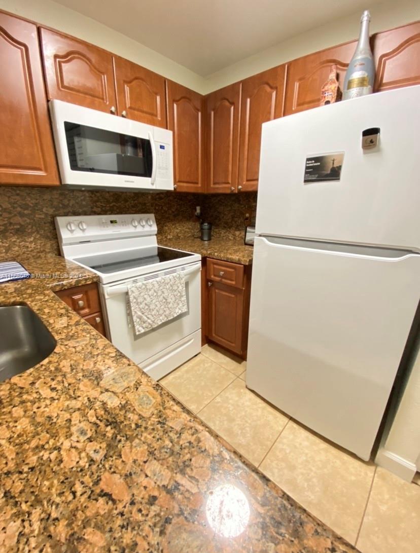 a kitchen with a refrigerator sink and microwave