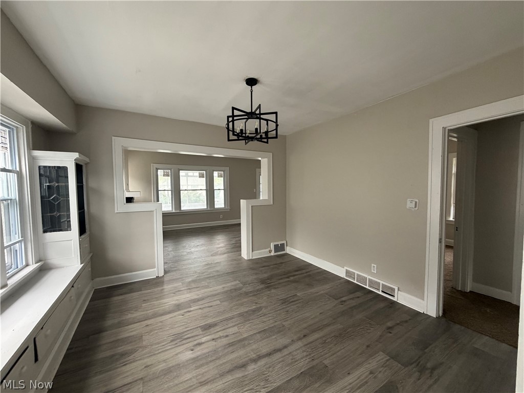 15317 Shiloh Road Cleveland, OH 44110 - Photo 17 of 29 Open-concept living space with wood-finish flooring, a contemporary black chandelier, and a built-in window bench with storage