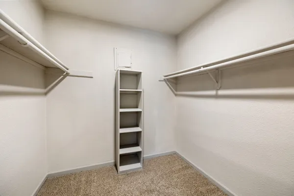 a view of walk in closet with empty racks