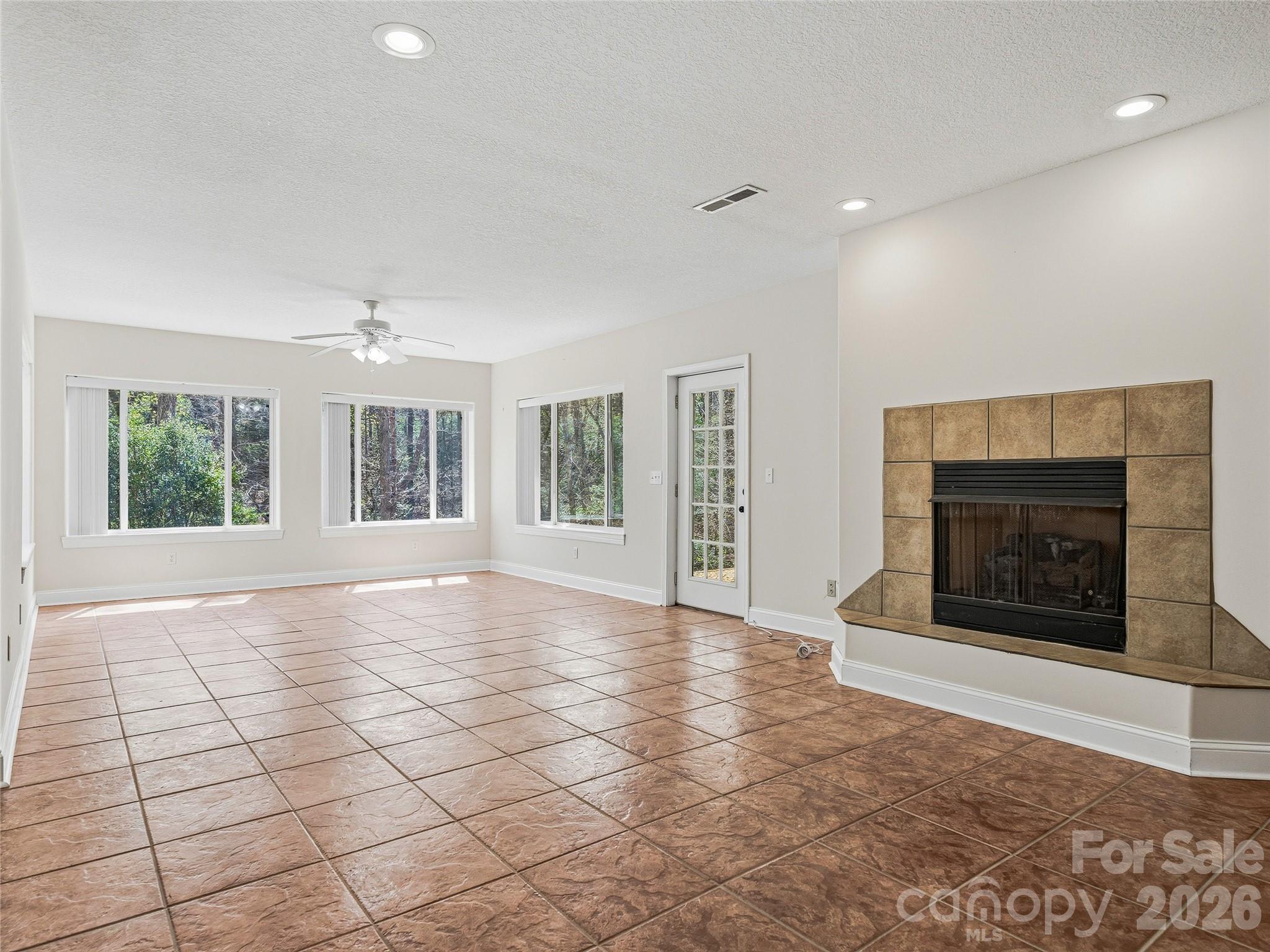 196 Blackbird Lane Tryon, NC 28782 - Photo 37 of 44 an empty room with windows and fireplace