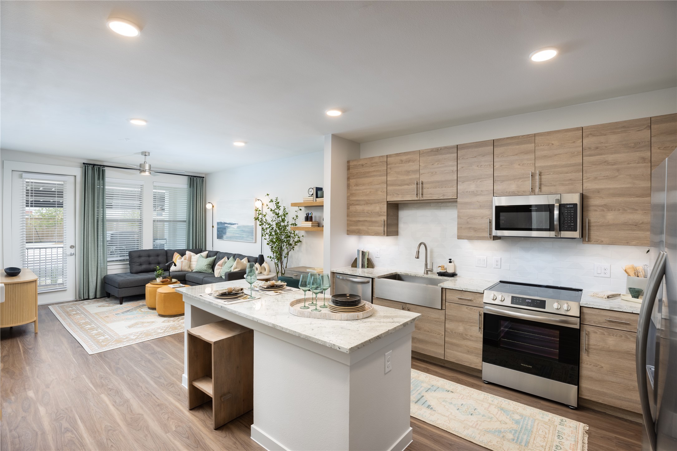 a kitchen with stainless steel appliances kitchen island granite countertop a sink dishwasher stove and refrigerator with wooden floor